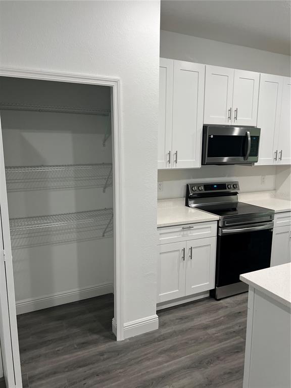 A kitchen features white cabinets, stainless steel appliances, quartz countertops, and an open pantry — 4455 SE 24TH STREET, OCALA, FL