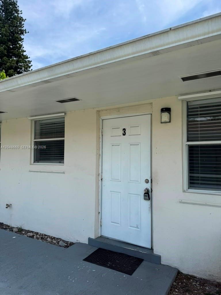 The exterior view shows a white building entrance with a door marked number three — 16001 NE 18th Pl # 3, North Miami Beach FL 33162, NORTH MIAMI BEACH, FL
