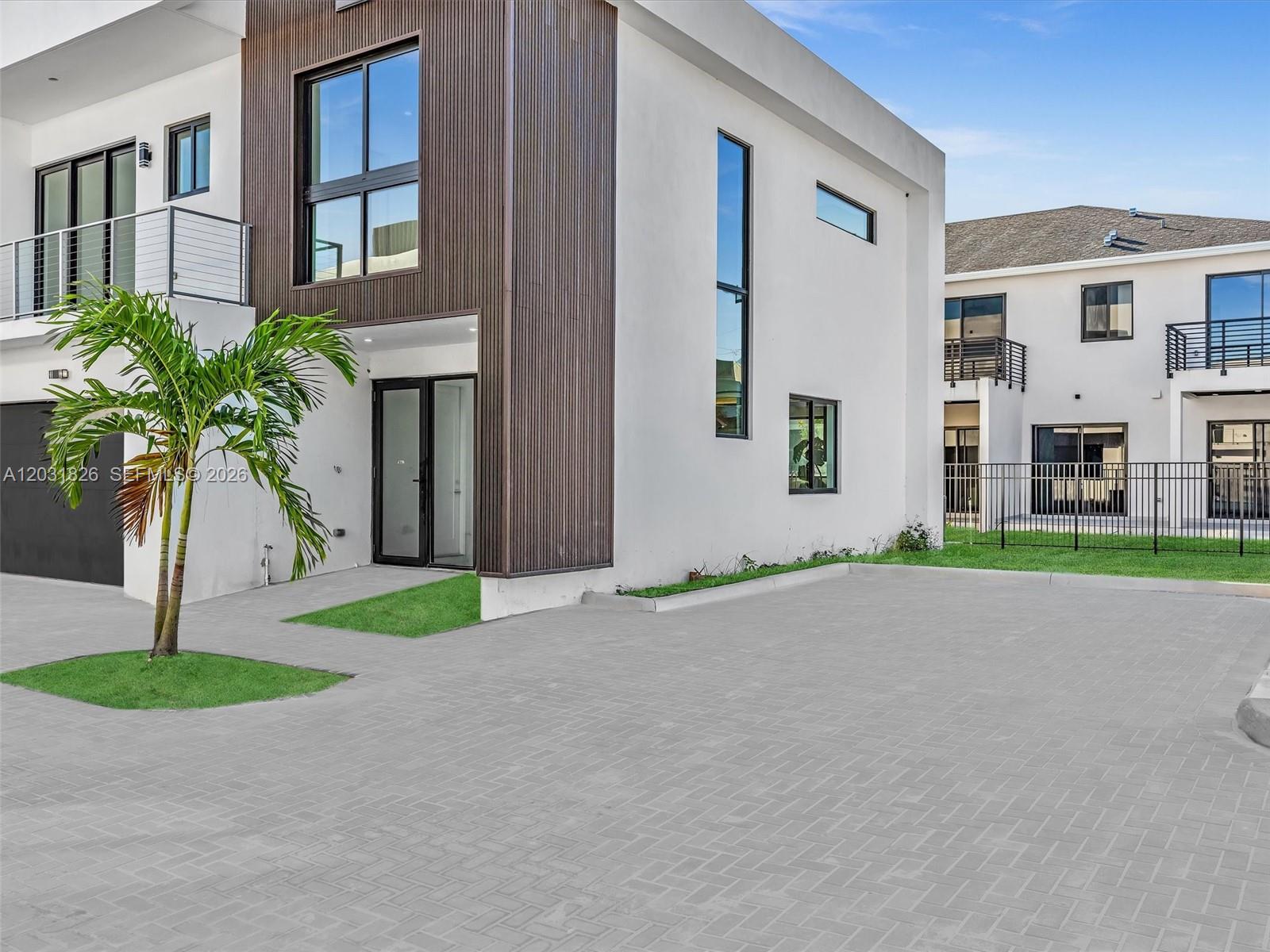 A modern two-story building with white walls, dark wood siding, and a paved driveway — 4656 SW 32nd Ave # B1, Dania Beach FL 33312, DANIA BEACH, FL