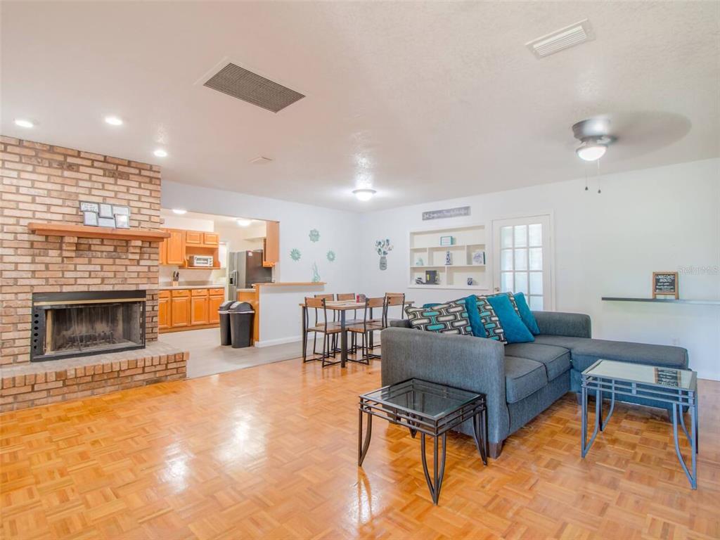 A living room features a brick fireplace, hardwood parquet flooring, and an adjacent dining area — 4401 LENMORE STREET, ORLANDO, FL