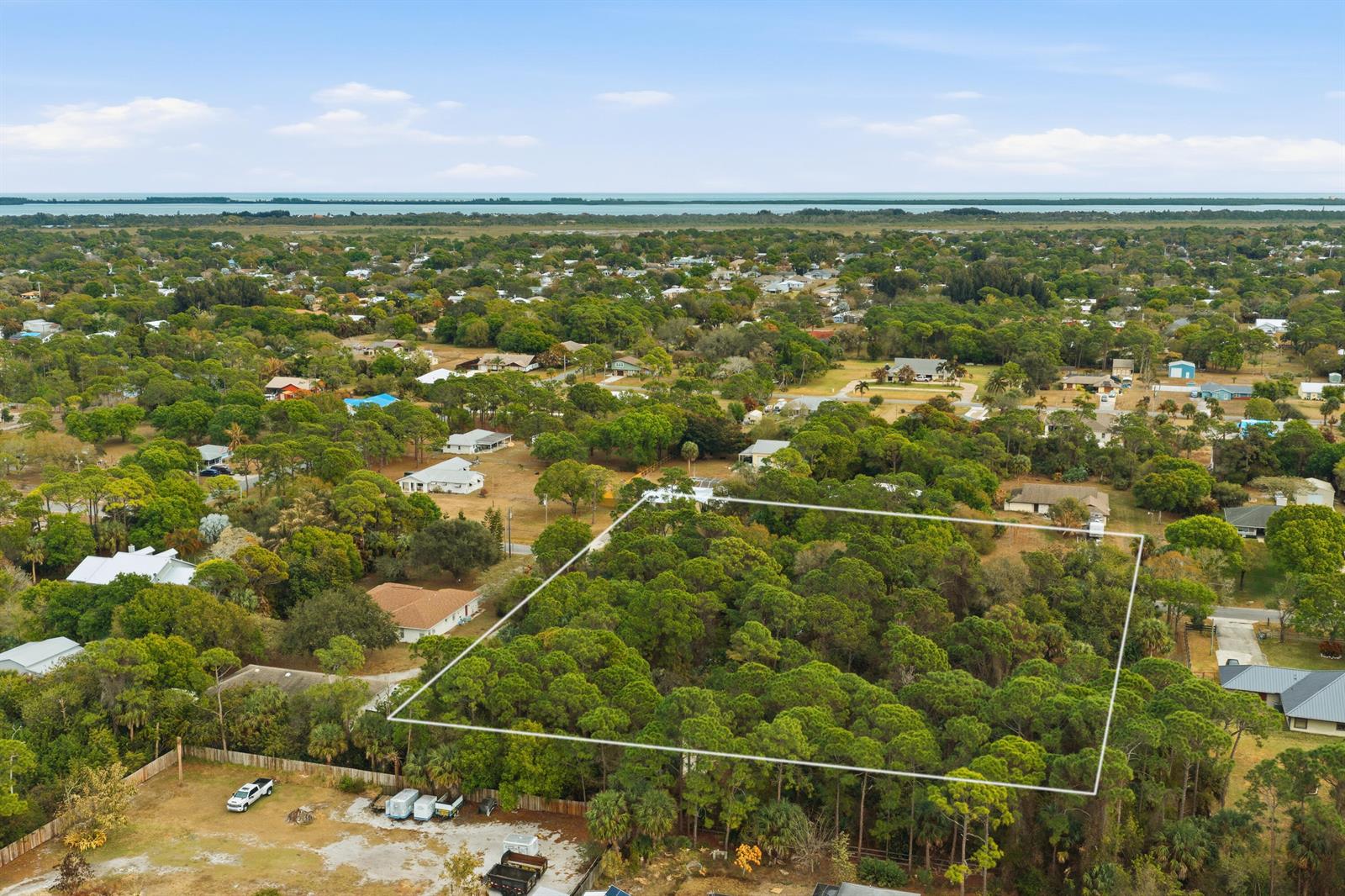 An aerial view shows a large, wooded rectangular lot outlined in white within a neighborhood — 0 Pinetree Drive, Fort Pierce FL 34982, FORT PIERCE, FL