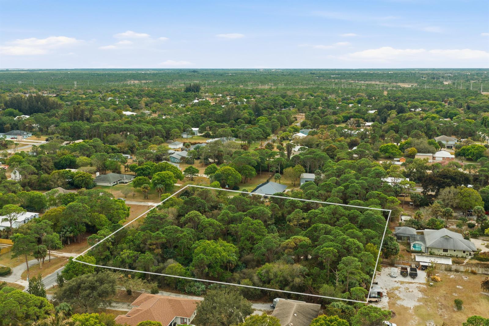An aerial view shows a rectangular, wooded vacant lot outlined in white within a neighborhood — 0 Pinetree Drive, Fort Pierce FL 34982, FORT PIERCE, FL