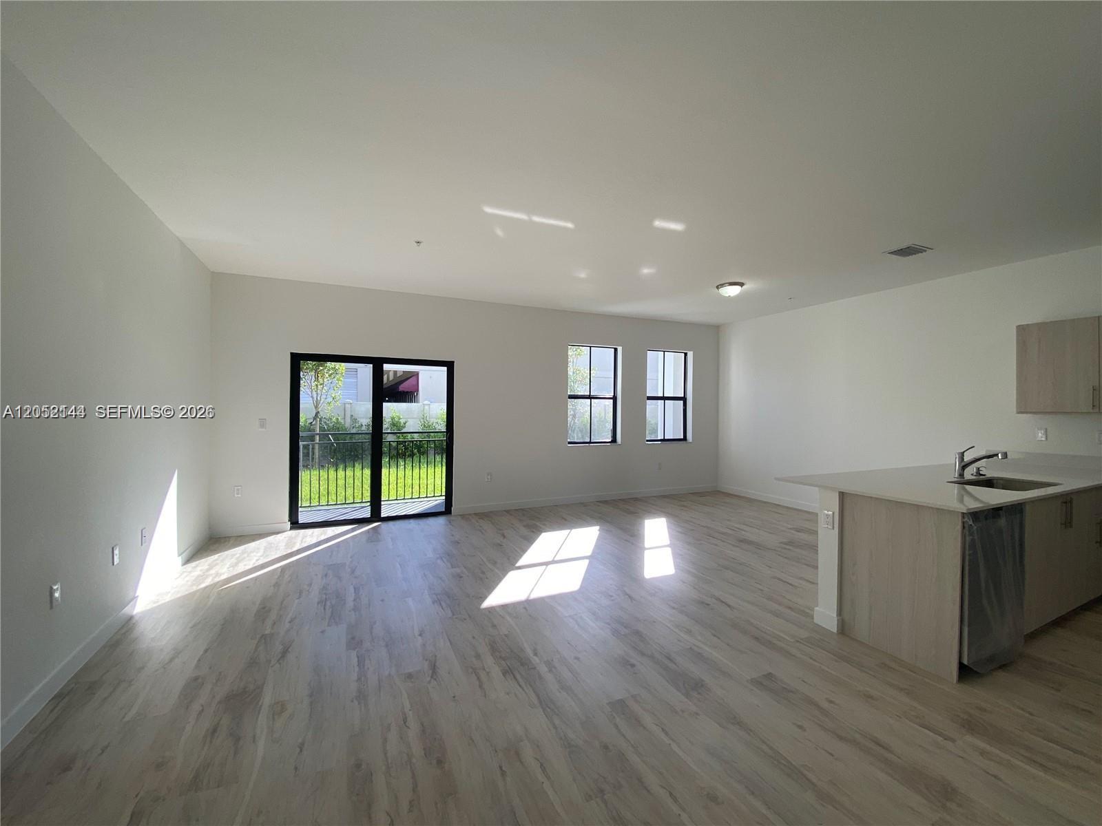 A living room features a grey sofa, a wooden coffee table, and a treadmill — 15540 SW 136th St # 105, Miami FL 33196, MIAMI, FL