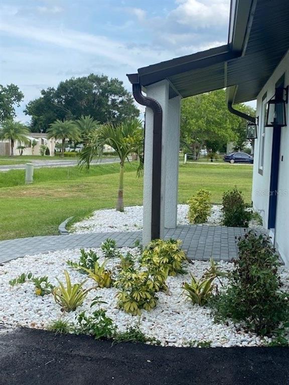 A paved walkway leads to a covered entryway with white rock landscaping and small shrubs — 2726 MIAMI TERRACE UNIT B, KISSIMMEE, FL