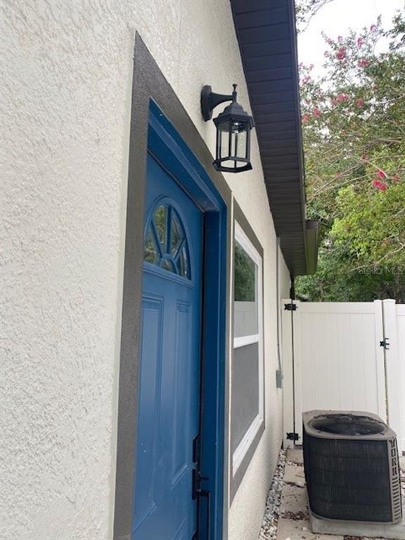 A blue door with a window and a black light fixture on a stucco exterior — 2726 MIAMI TERRACE UNIT B, KISSIMMEE, FL