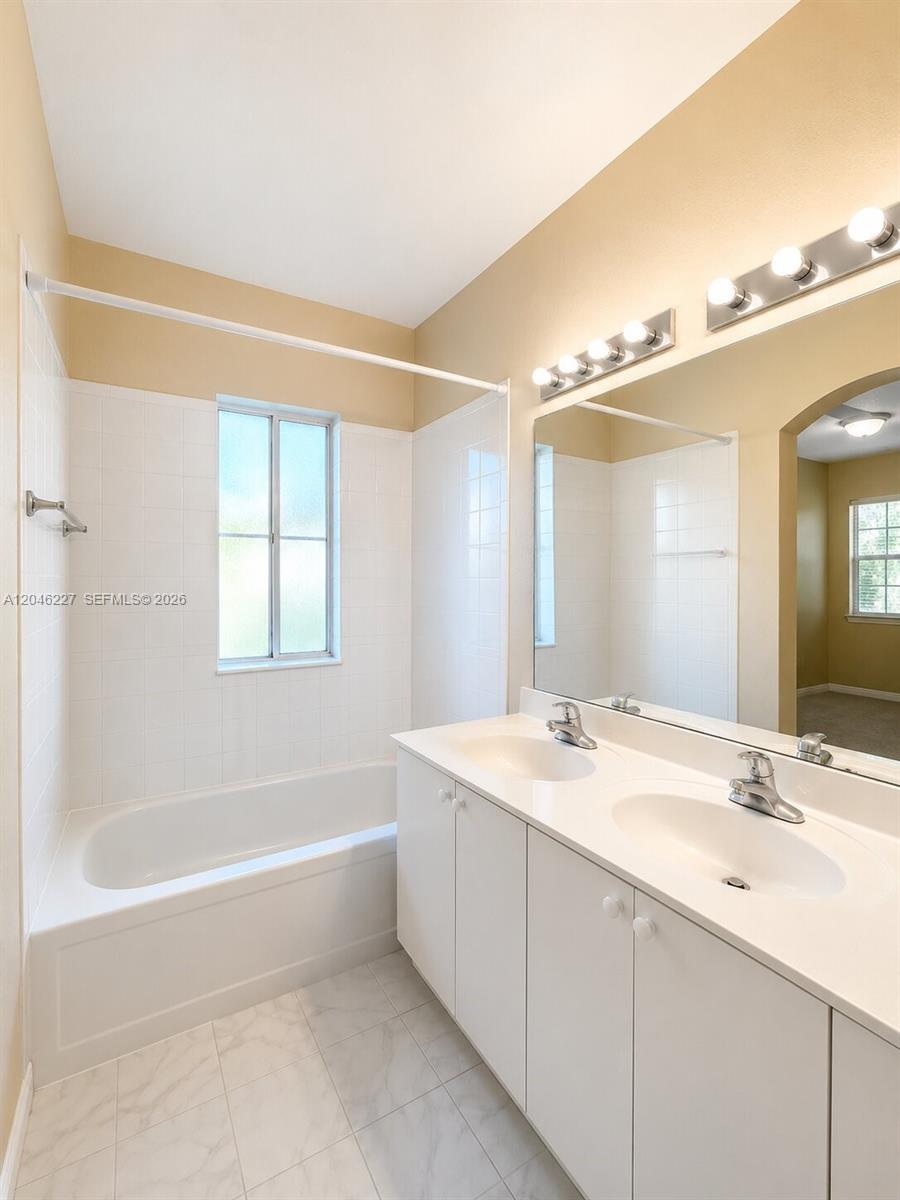 This bathroom features a white double vanity, a shower-tub combination, and a large wall mirror — 8526 NW 107th Psge # 40, Doral FL 33178, DORAL, FL