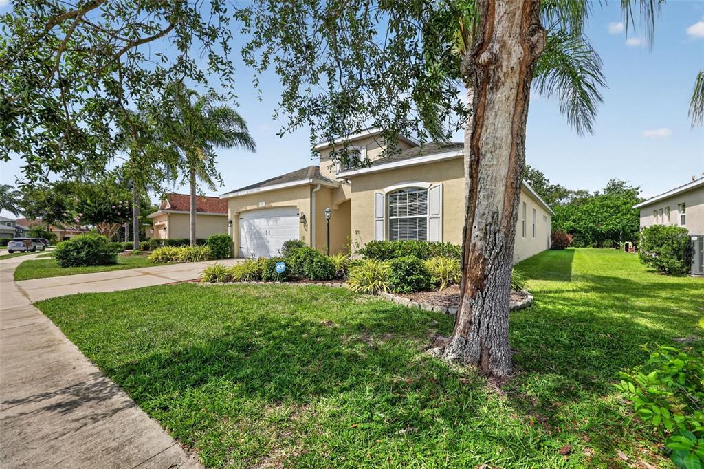 A single-story house with a beige stucco exterior, a two-car garage, and a front lawn — 5328 LEXINGTON DRIVE, PARRISH, FL