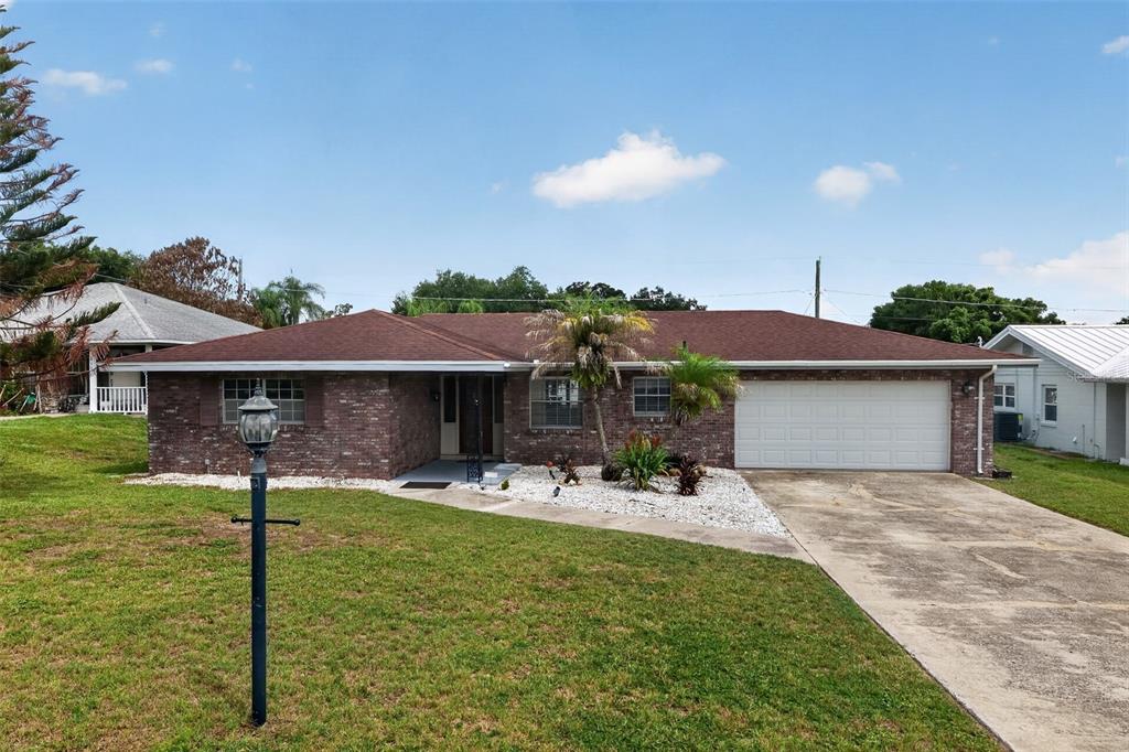 A single-story brick house with a brown roof, a two-car garage, and a front lawn — 516 ALACHUA DRIVE, WINTER HAVEN, FL