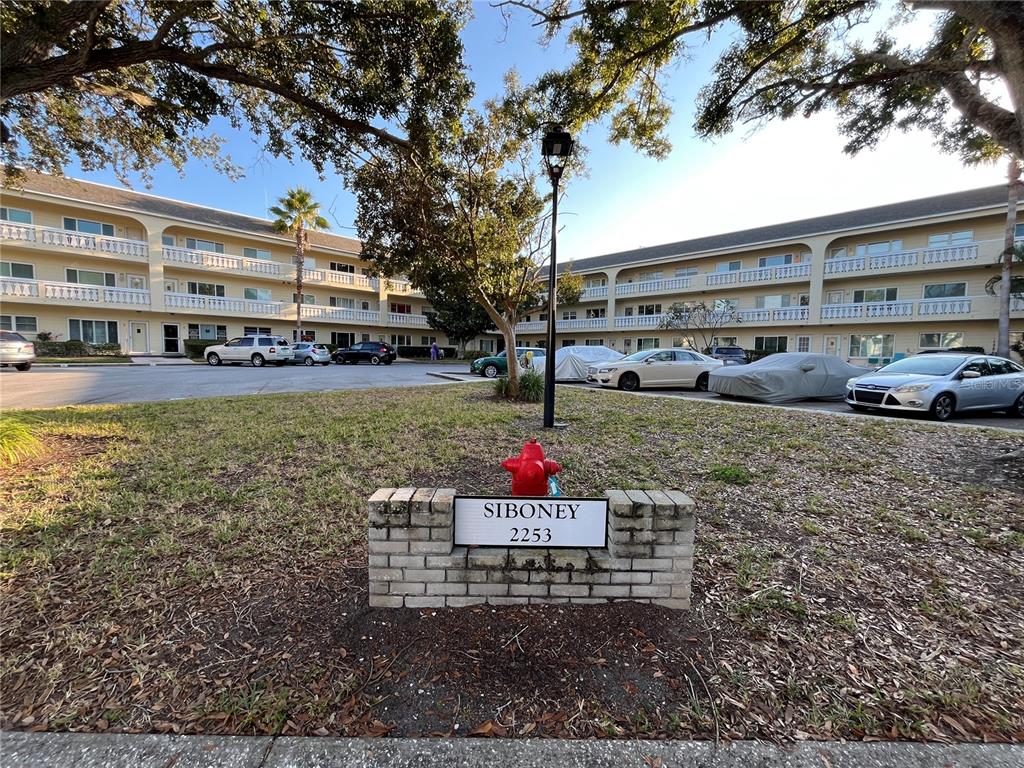 A brick sign labeled Siboney 2253 stands in front of a multi-story apartment building — 2253 NORWEGIAN DRIVE UNIT 33, CLEARWATER, FL