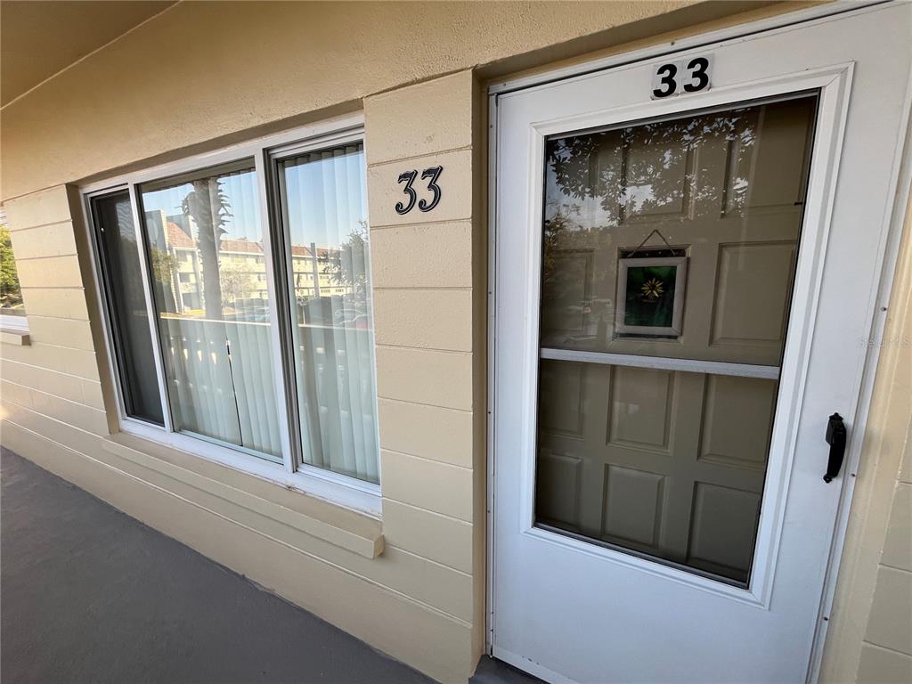 A beige exterior wall features a window and a white door marked with number 33 — 2253 NORWEGIAN DRIVE UNIT 33, CLEARWATER, FL