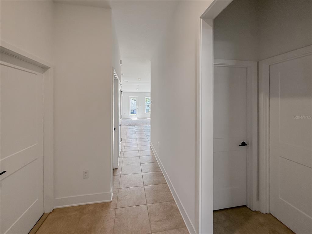 A bright, open-concept living and dining area features tile flooring, carpeted space, and a chandelier — 270 VERNY GROVE LANE, LEESBURG, FL