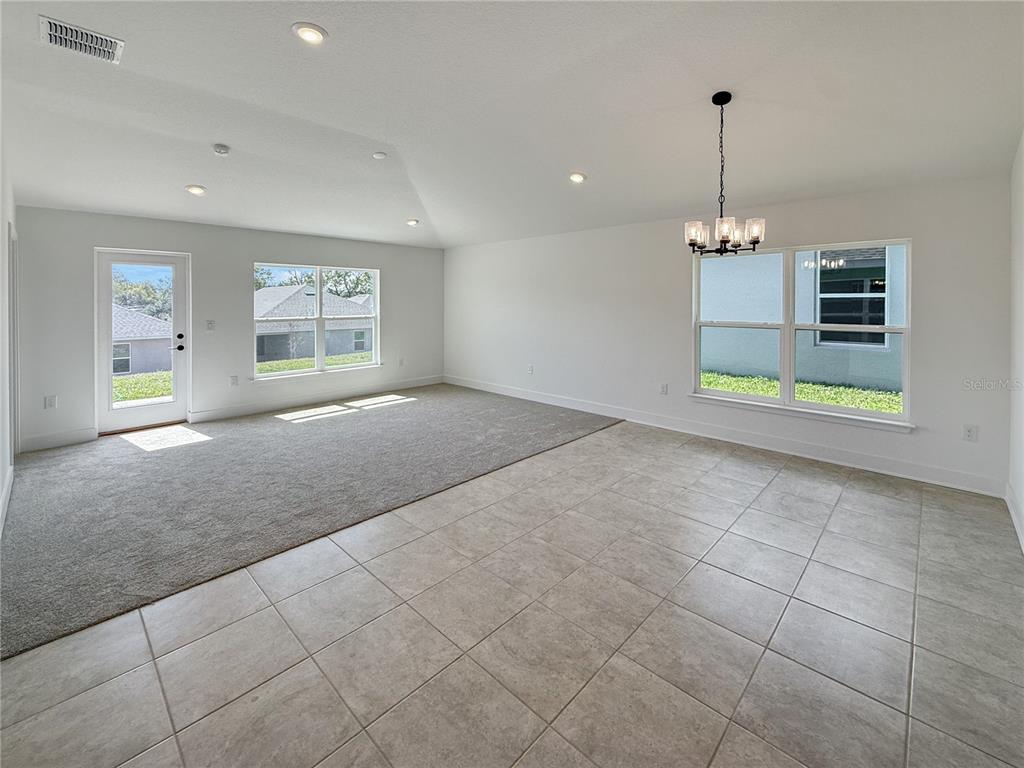 A bedroom with white walls, gray carpet, a double-door closet, and an open doorway — 270 VERNY GROVE LANE, LEESBURG, FL