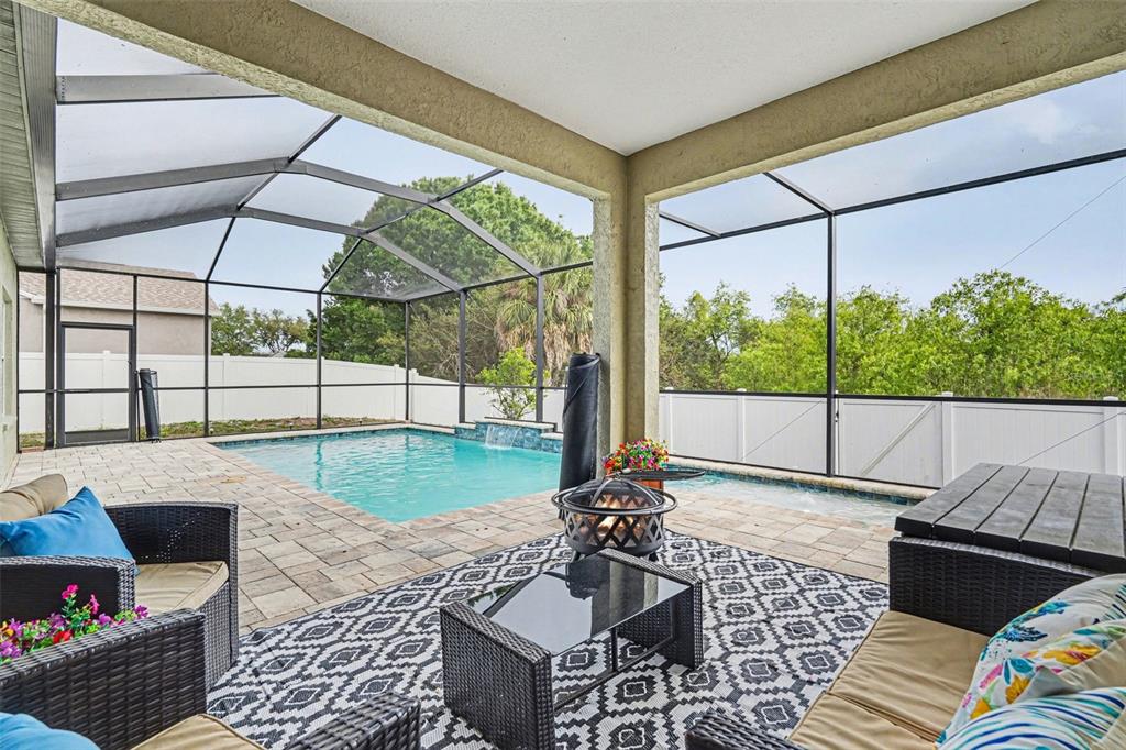 A screened-in patio features a swimming pool, a fire pit, and outdoor wicker furniture — 9637 WYDELLA STREET STREET, RIVERVIEW, FL