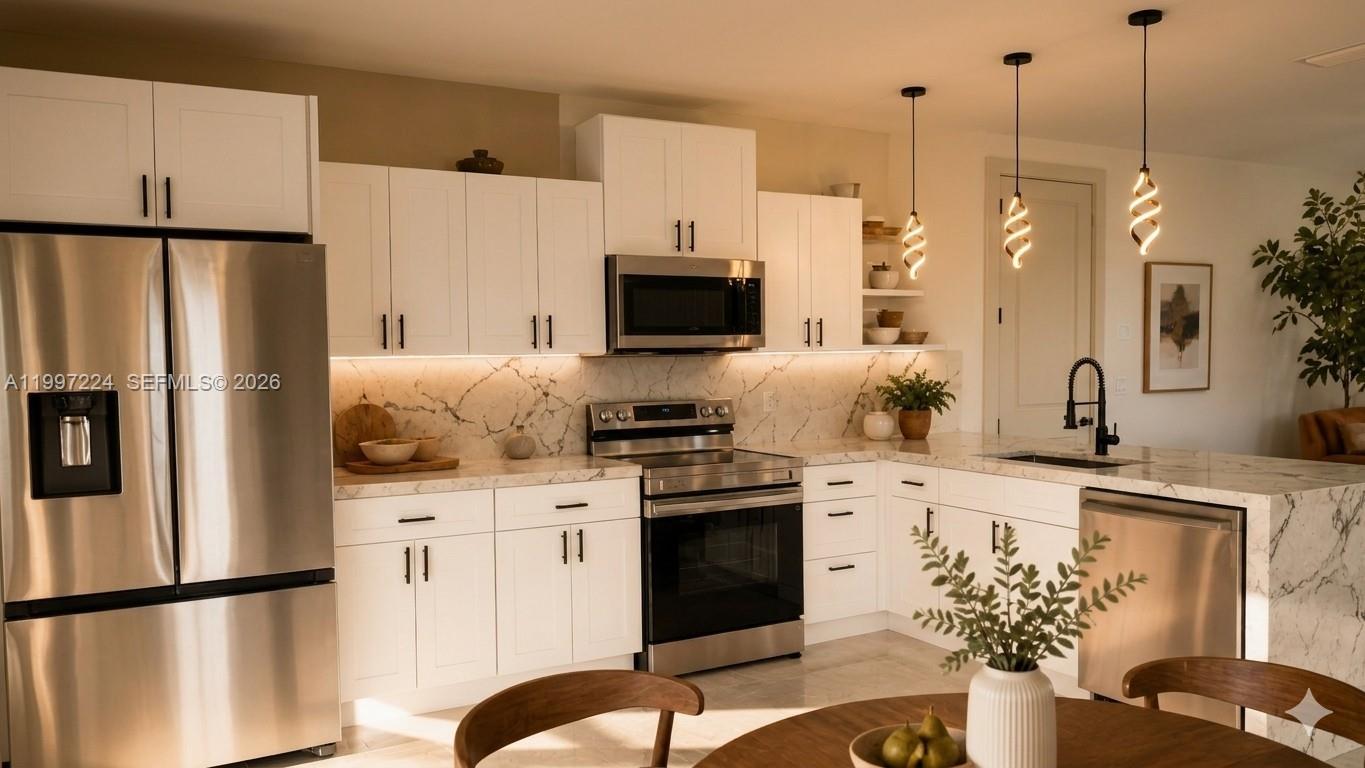A modern kitchen features white cabinetry, stainless steel appliances, and marble countertops with a backsplash — 726 Clancy St E, Lehigh Acres FL 33974, LEHIGH ACRES, FL