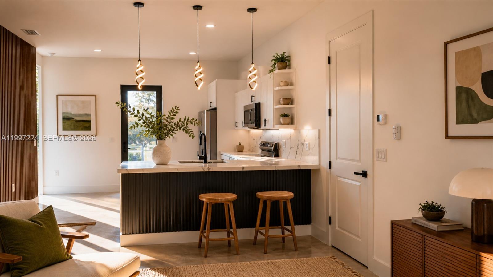 A modern kitchen features a dark slatted island, white marble countertops, and three pendant lights — 726 Clancy St E, Lehigh Acres FL 33974, LEHIGH ACRES, FL