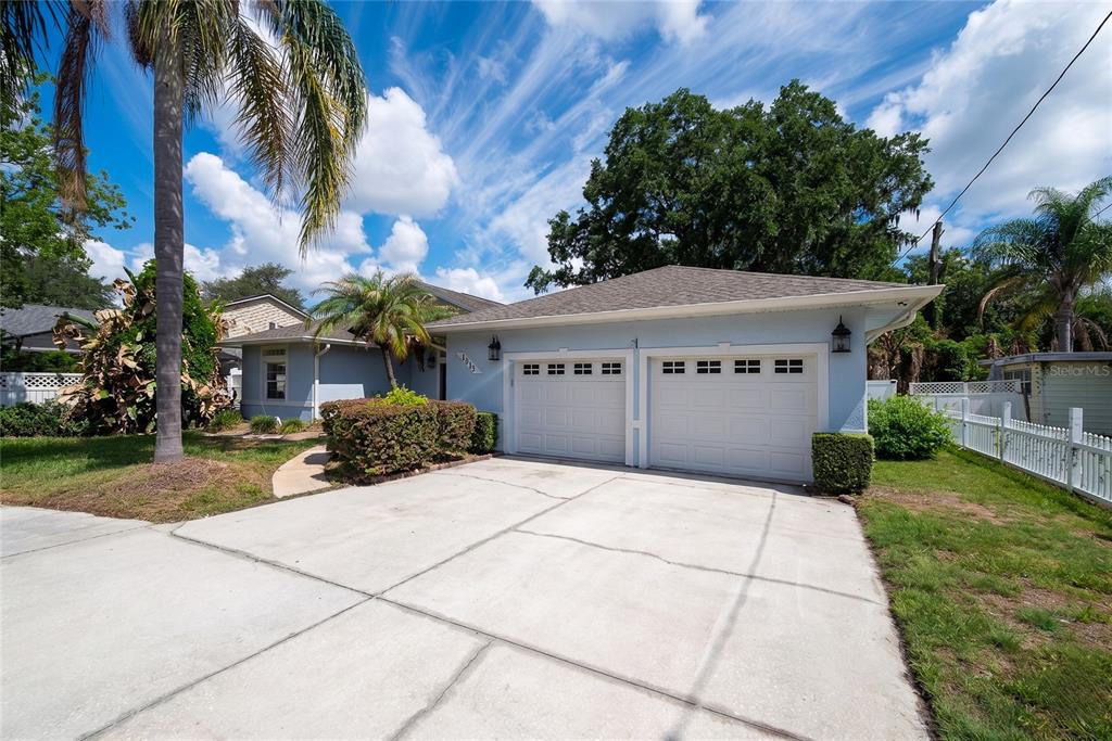A light blue single-story house features a two-car garage and a concrete driveway — 1015 VENETIAN AVENUE, ORLANDO, FL