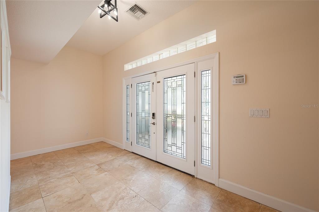 An entryway features tile flooring, double glass-paneled doors, and a transom window above — 1015 VENETIAN AVENUE, ORLANDO, FL