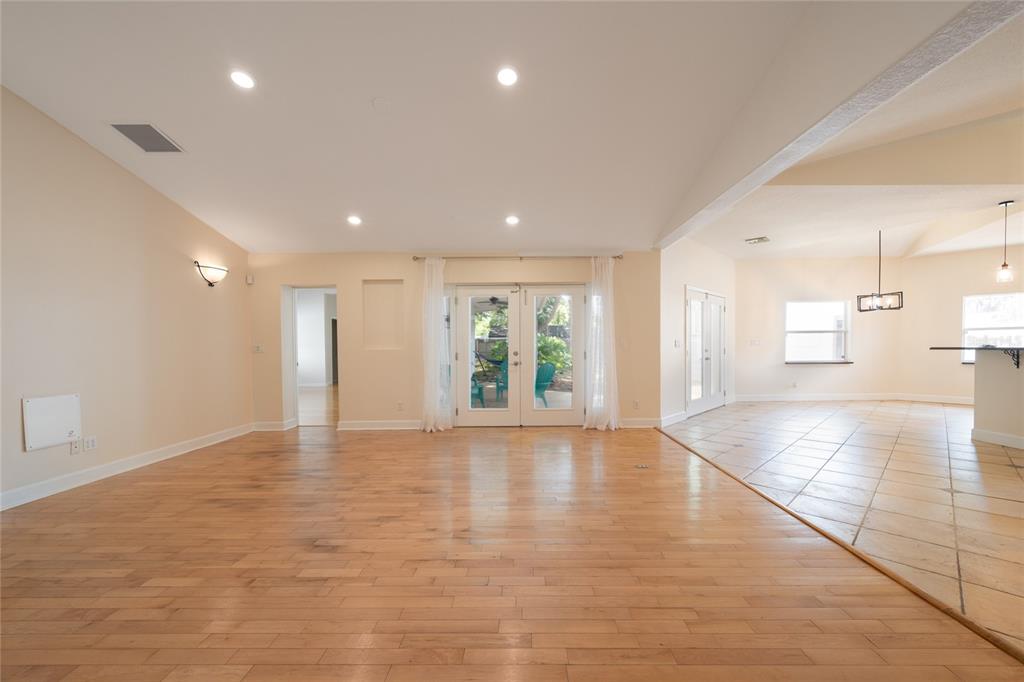 A spacious living room with hardwood floors, recessed lighting, and glass doors leading outside — 1015 VENETIAN AVENUE, ORLANDO, FL