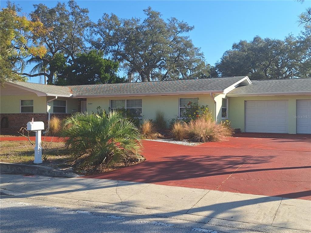 A single-story house with a red driveway, light-colored siding, and a two-car garage — 505 N HIGHLAND AVENUE, CLEARWATER, FL