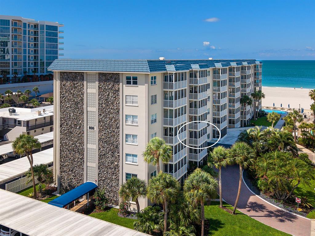 An exterior view of a multi-story beachfront condominium building with a circled balcony — 800 BENJAMIN FRANKLIN DRIVE UNIT 304, SARASOTA, FL