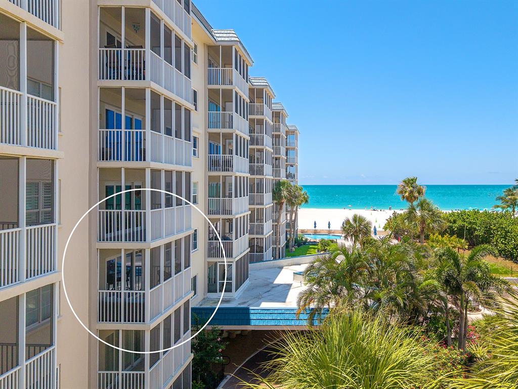An exterior view of a multi-story beachfront condominium building with screened-in balconies — 800 BENJAMIN FRANKLIN DRIVE UNIT 304, SARASOTA, FL