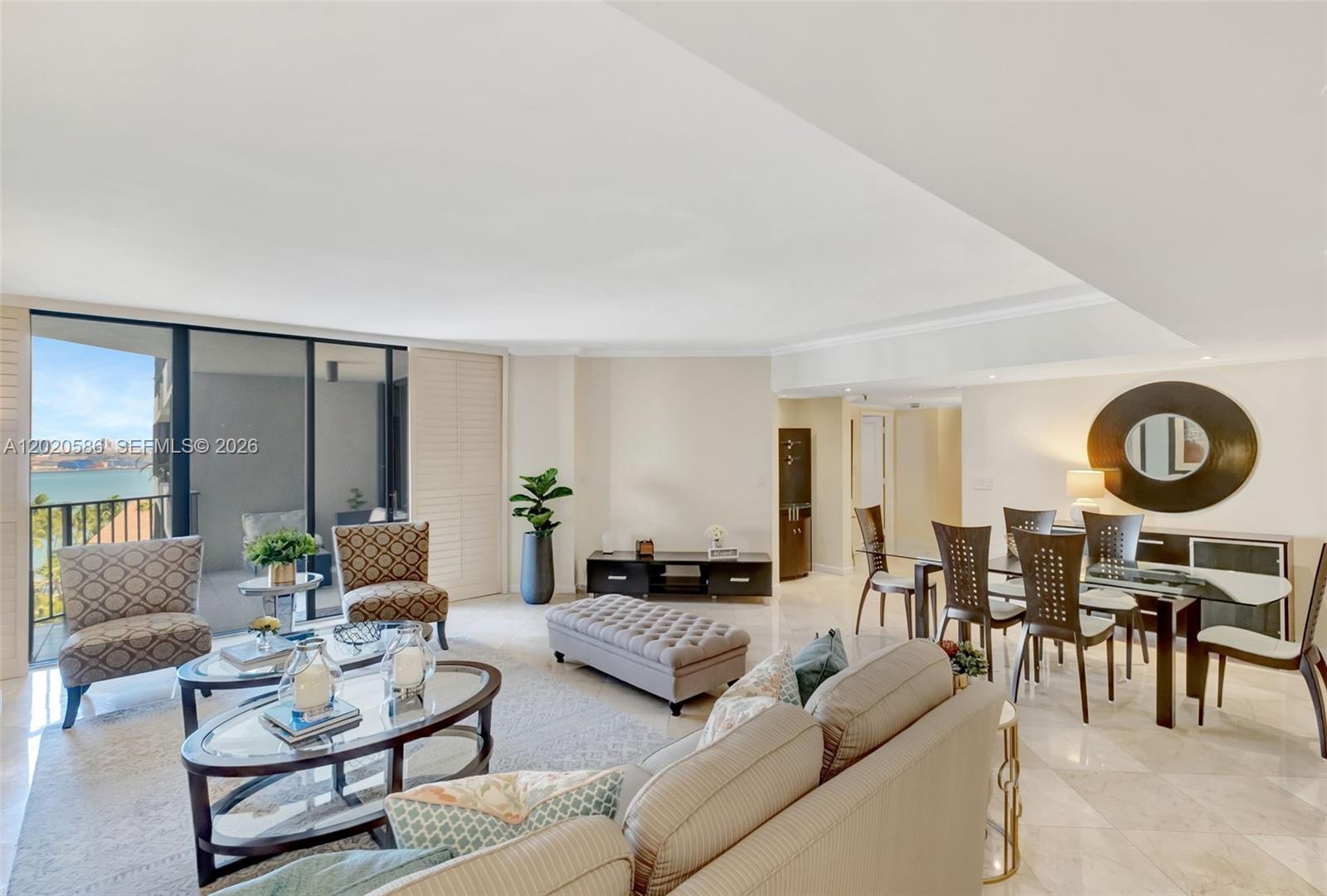 A living and dining area features marble floors, a glass-topped table, and a balcony view — 520 Brickell Key Dr # A914, Miami FL 33131, MIAMI, FL