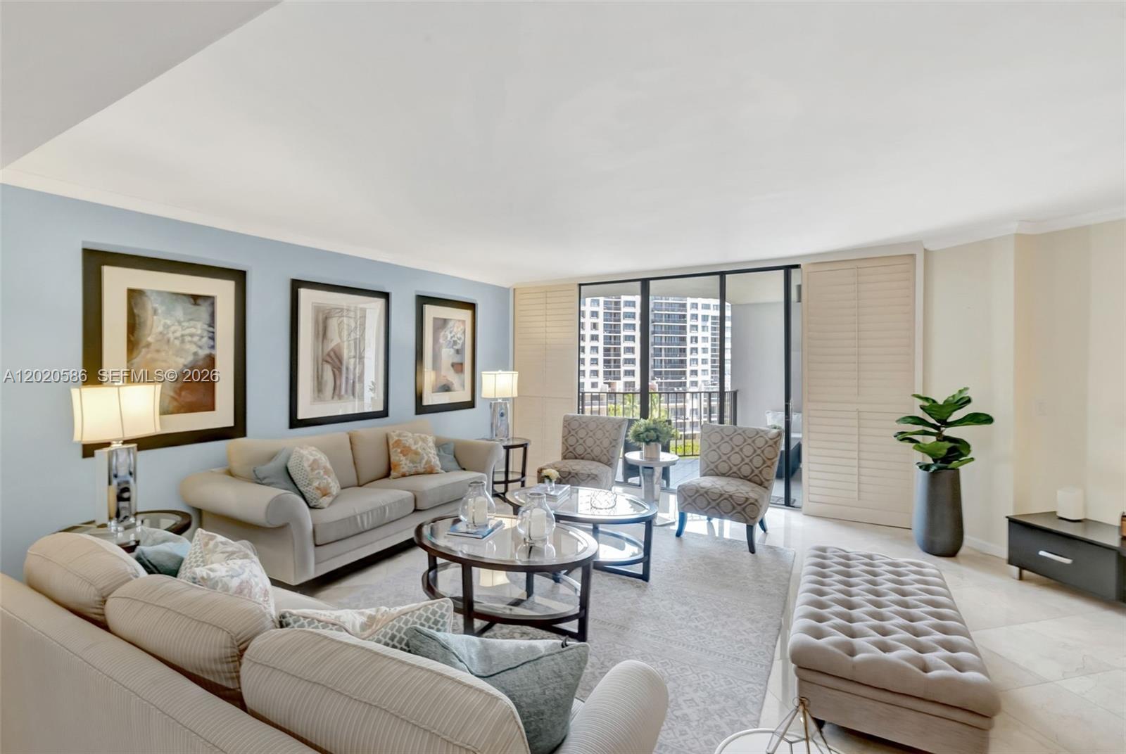A living room features light blue walls, two sofas, patterned armchairs, and a glass balcony door — 520 Brickell Key Dr # A914, Miami FL 33131, MIAMI, FL