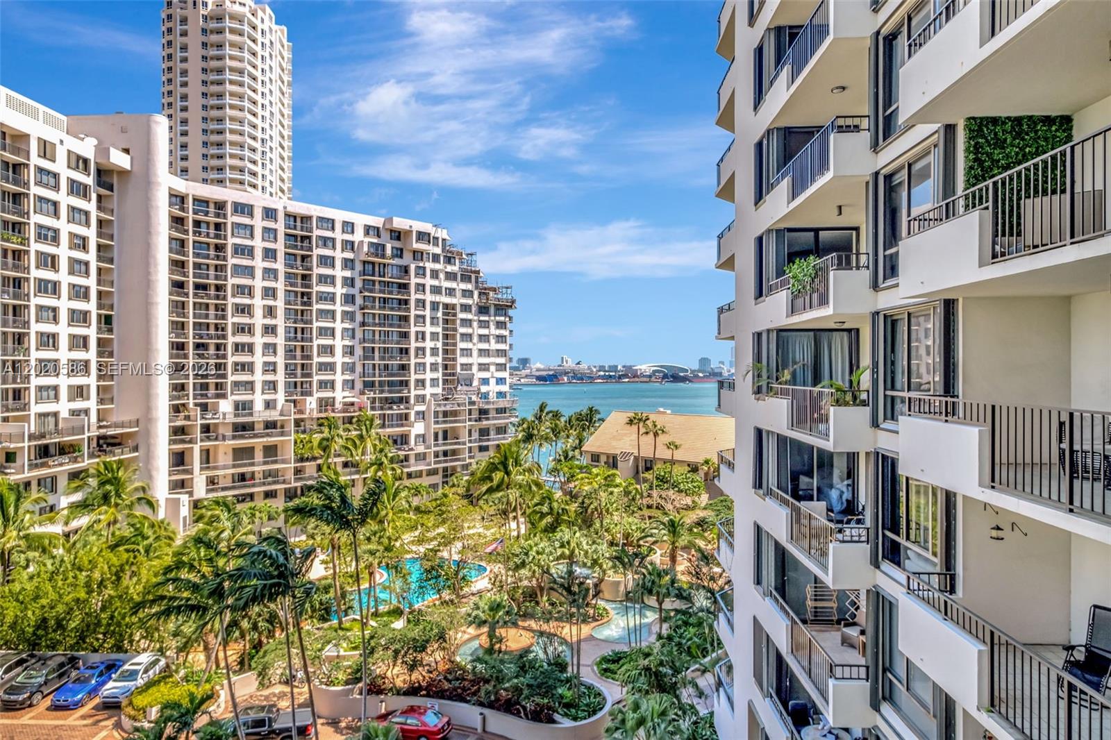 An elevated view of a tropical courtyard with a pool between two large apartment buildings — 520 Brickell Key Dr # A914, Miami FL 33131, MIAMI, FL