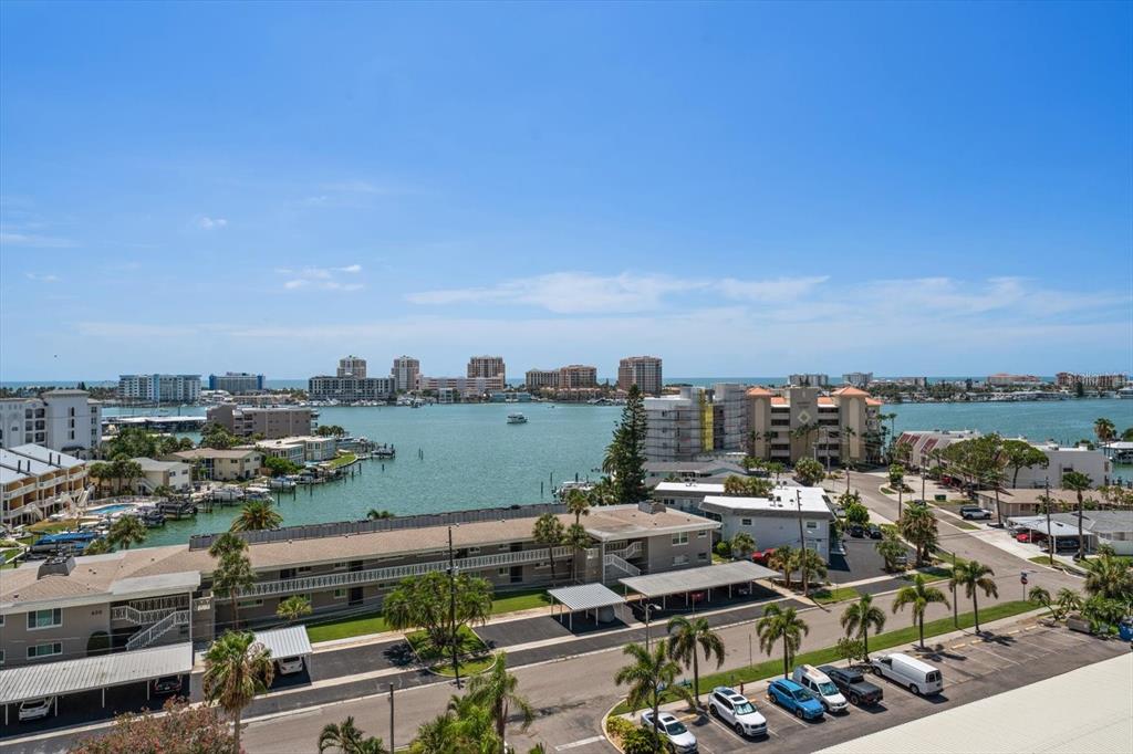 An elevated view of a coastal residential area with a bay, boats, and apartment buildings — 400 ISLAND WAY UNIT 904, CLEARWATER BEACH, FL