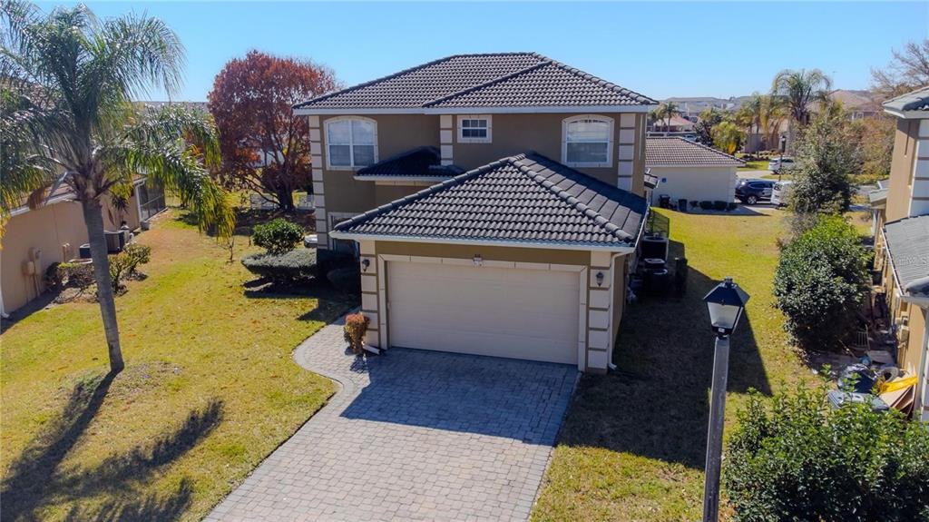 An aerial view of a two-story house with a tiled roof and paved driveway — 416 VISTA LOOP, DAVENPORT, FL