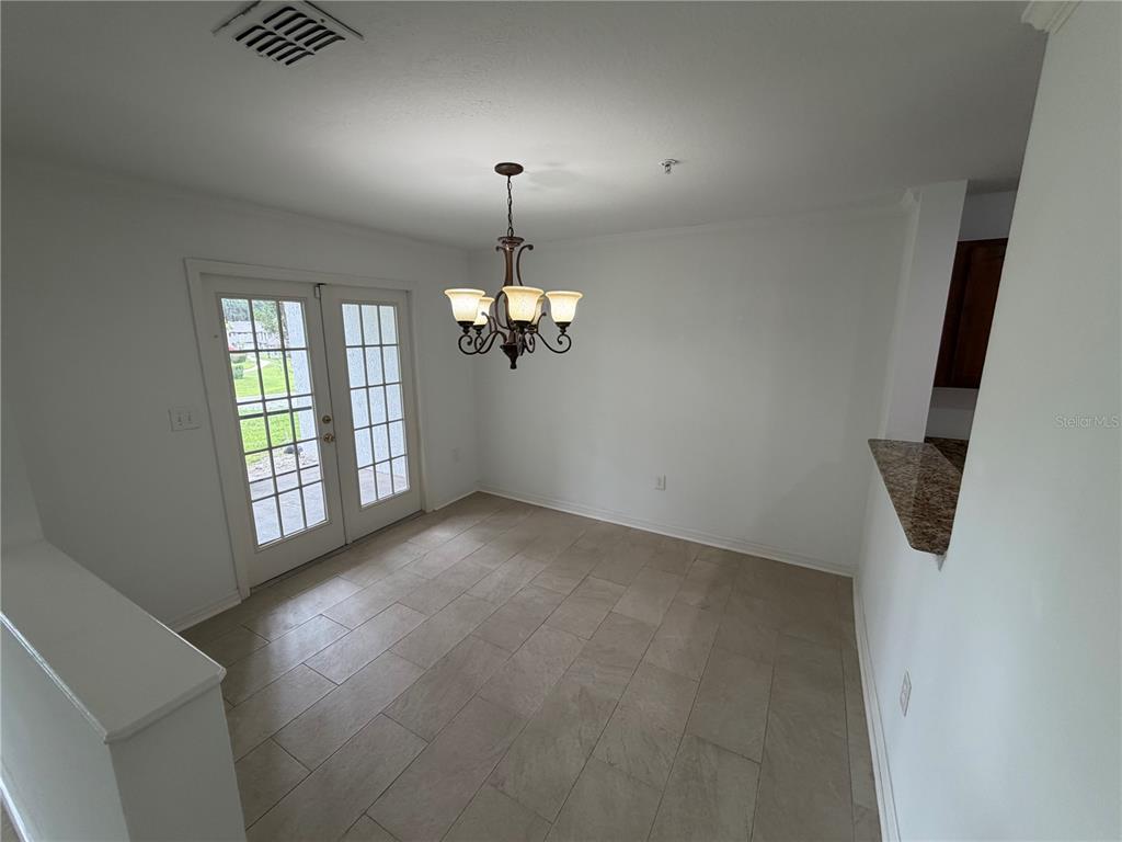 A dining area features tile flooring, a chandelier, and French doors leading to the outdoors — 110 OLIVE TREE CIRCLE UNIT 110, ALTAMONTE SPRINGS, FL