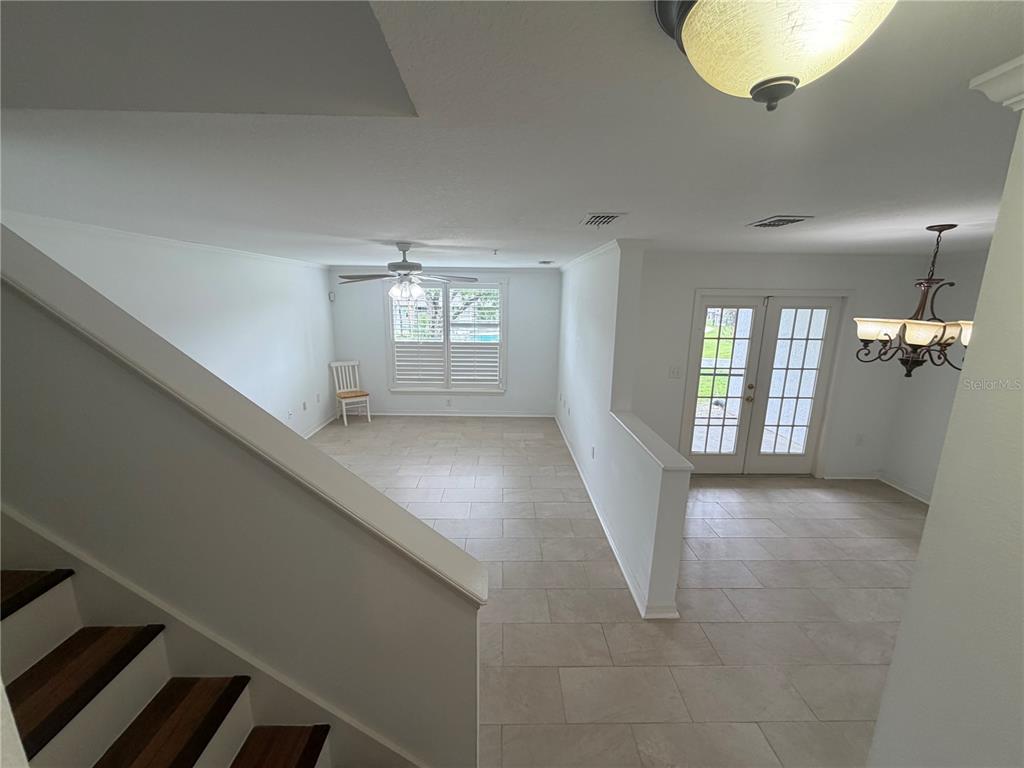 A living area with tile flooring, a staircase, and French doors leading outside — 110 OLIVE TREE CIRCLE UNIT 110, ALTAMONTE SPRINGS, FL