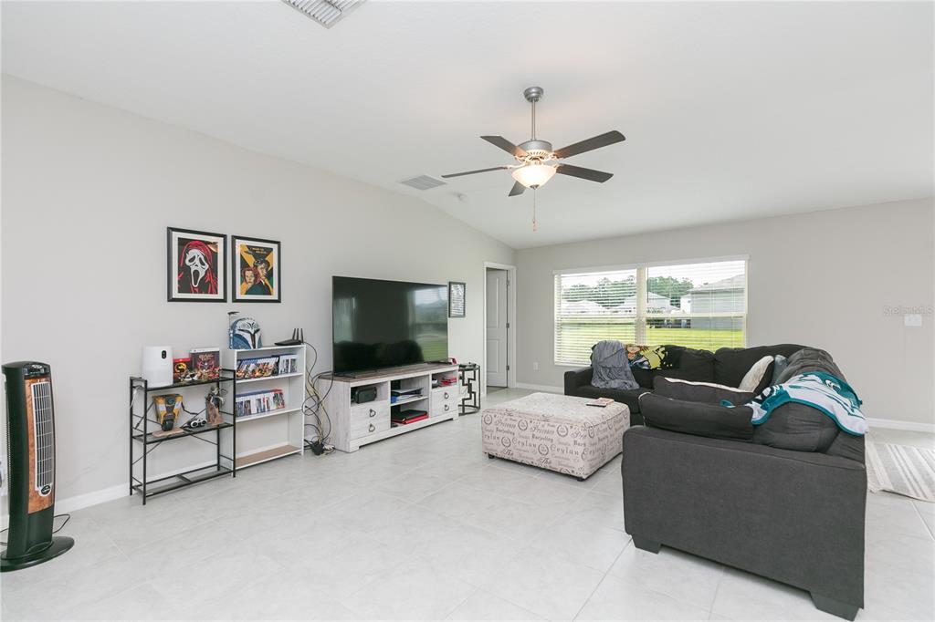 A living room features light tile floors, a ceiling fan, a television console, and a sofa — 13608 WILLOW BLUESTAR LOOP, RIVERVIEW, FL