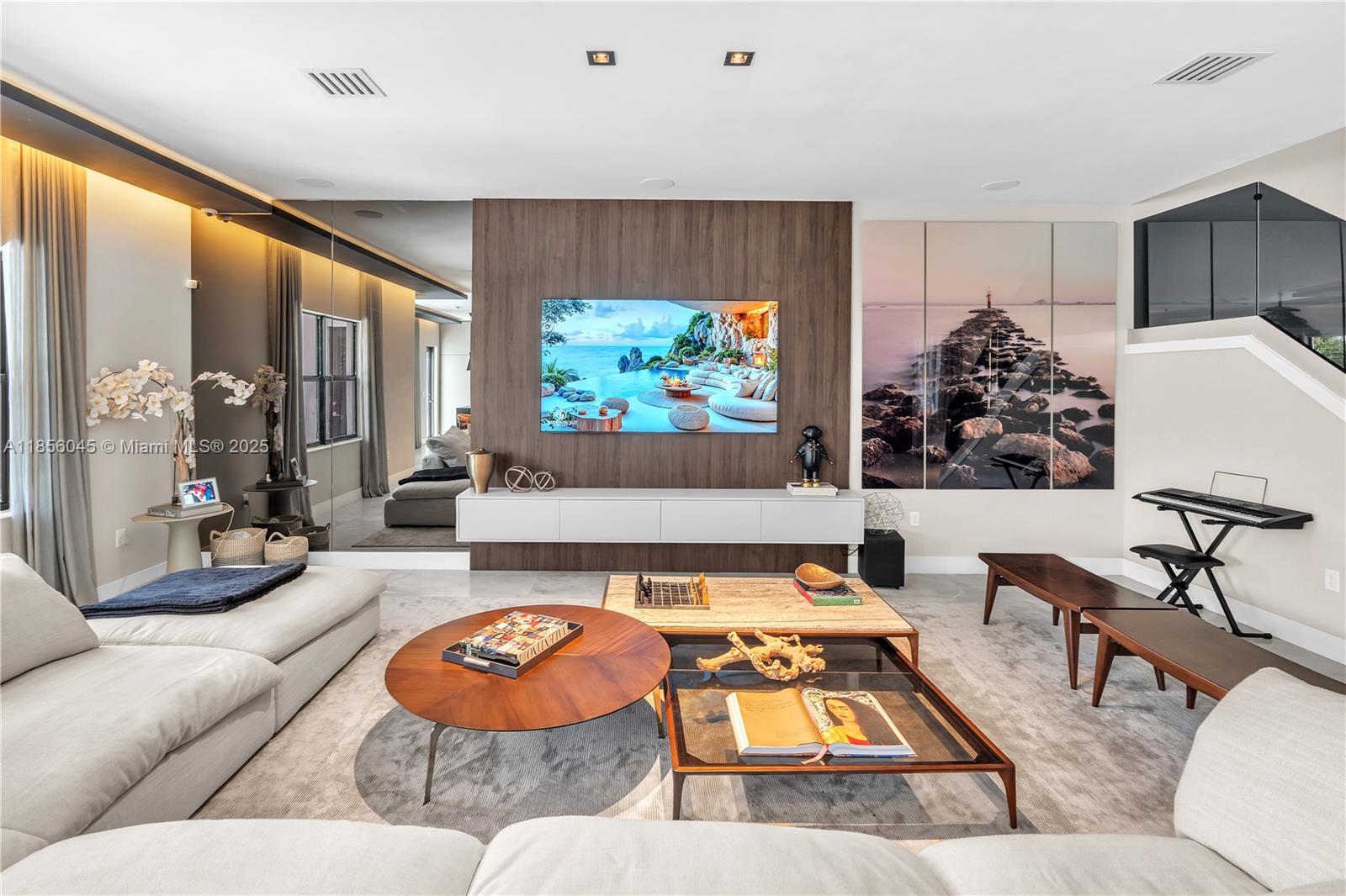 A modern living room features a wood-paneled media wall, a large sectional sofa, and coffee tables — 4335 SW 173rd Ave, Miramar FL 33029, MIRAMAR, FL