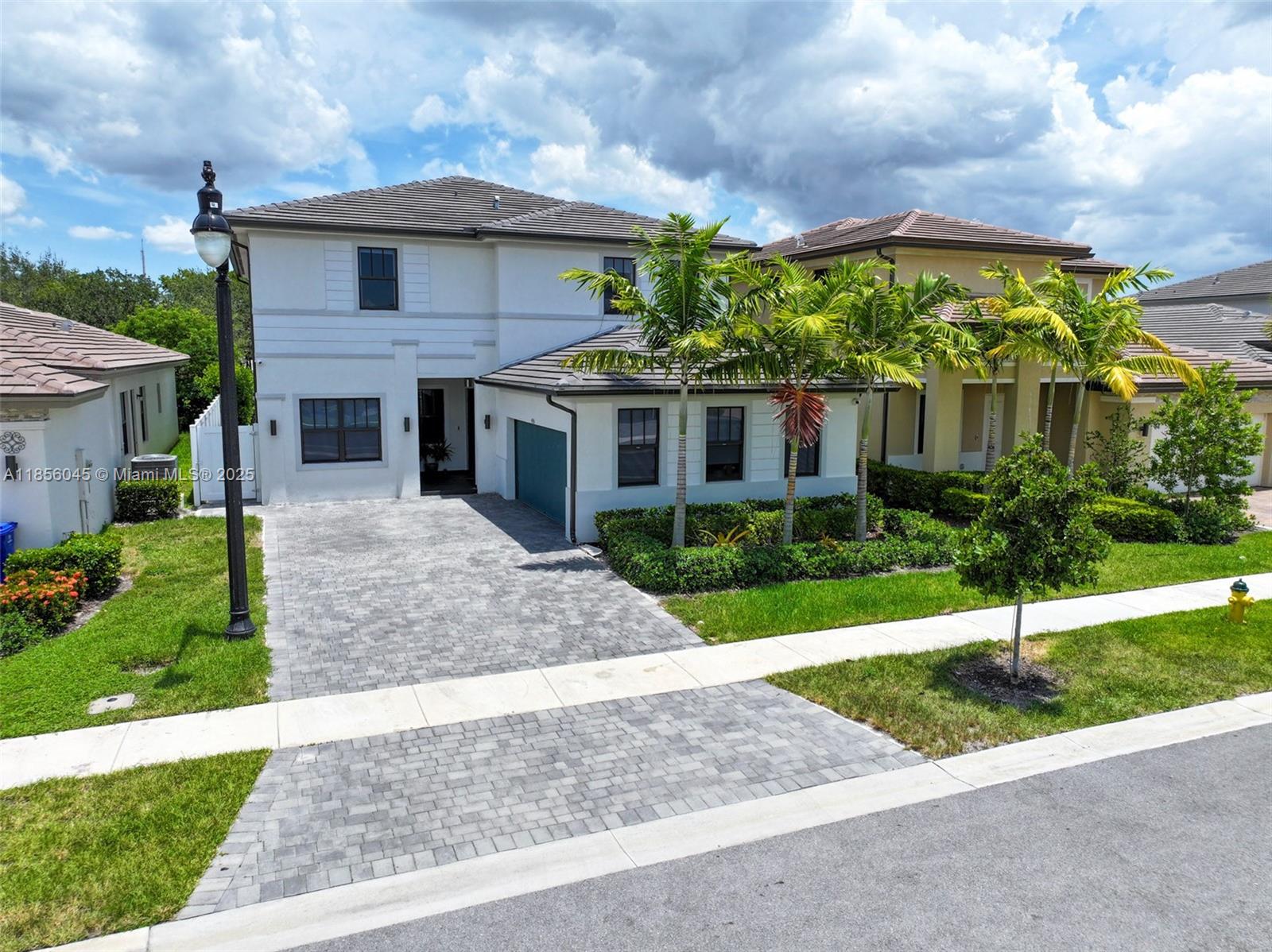 A two-story white house features a paved driveway, palm trees, and a tiled roof — 4335 SW 173rd Ave, Miramar FL 33029, MIRAMAR, FL