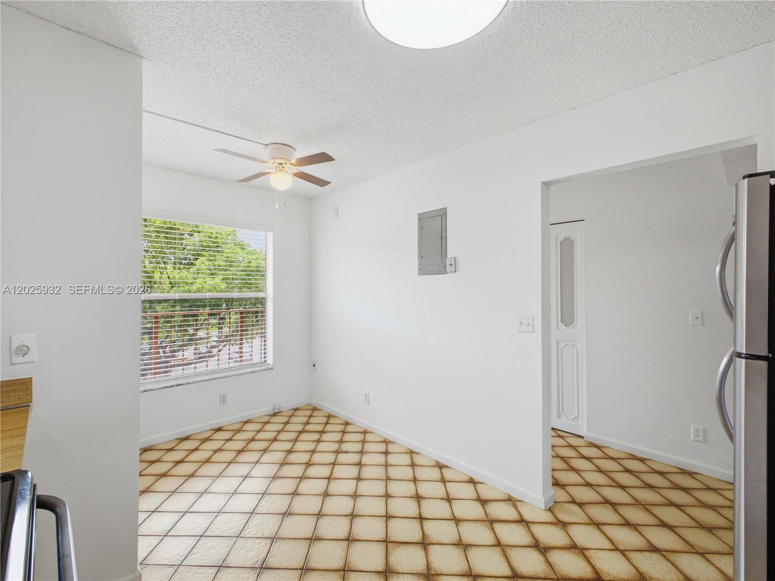 An empty room with tiled floors, a ceiling fan, and a window overlooking trees — 14623 Bonaire Blvd # 405, Delray Beach FL 33446, DELRAY BEACH, FL