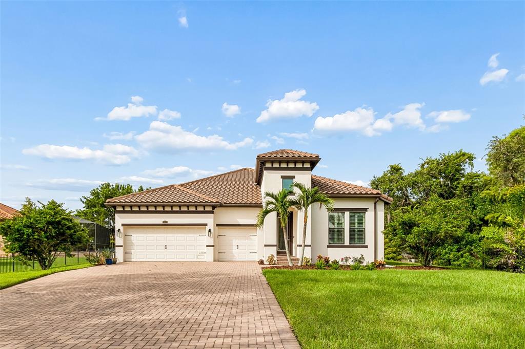 A single-story house with a tiled roof, two-car garage, and a central tower entrance — 7872 MARSH POINTE DRIVE, TAMPA, FL