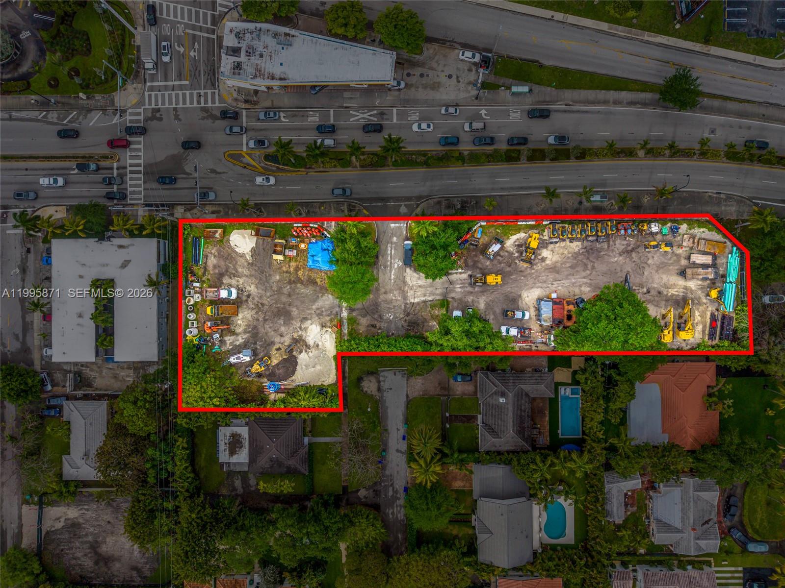 This aerial view shows a vacant, fenced-in construction lot surrounded by residential and commercial properties — 5445 & 5501 Biscayne Blvd, Miami FL 33137, MIAMI, FL