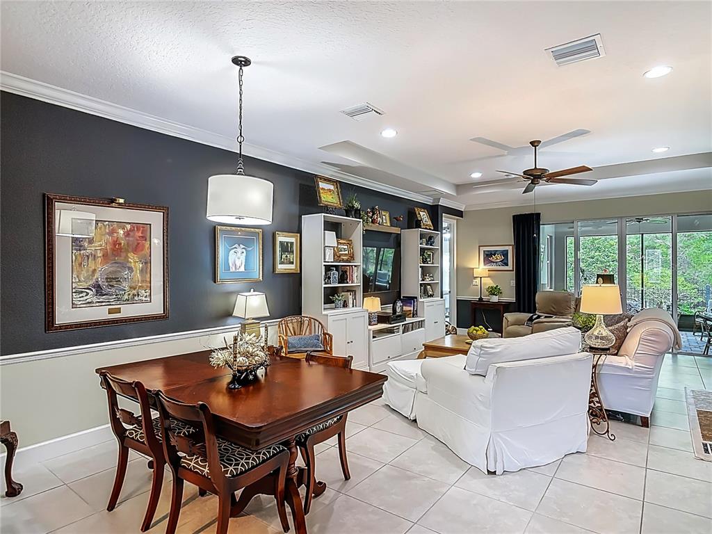 A dining area and living room feature dark accent walls, tile flooring, and white furniture — 1169 AVERY MEADOWS WAY, DELAND, FL