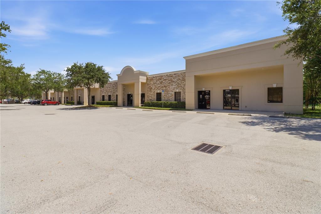 A single-story commercial building with a stone facade and a large paved parking lot — 4009 W 1ST STREET, SANFORD, FL