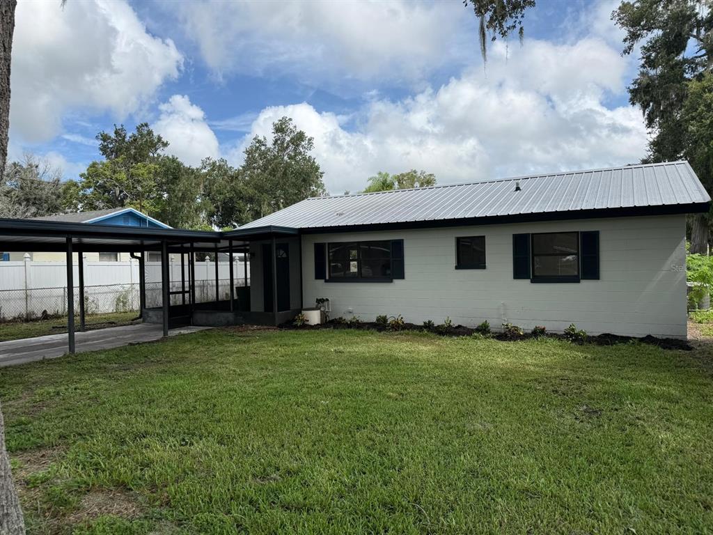 A single-story house with a metal roof, gray exterior, and an attached carport — 430 LUCILLE STREET, BARTOW, FL