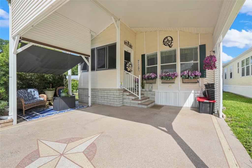 A mobile home with a carport, concrete driveway, and a small front porch with stairs — 9000 US HIGHWAY 192 UNIT 389, CLERMONT, FL