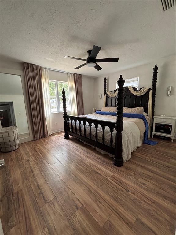 A bedroom features a dark wood four-poster bed, wood-look flooring, and floor-length curtains — 4420 DR MARTIN LUTHER KING JR STREET N, ST PETERSBURG, FL