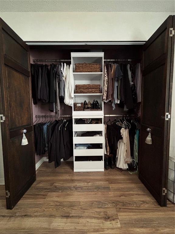 A reach-in closet features dark wood doors, a central white shelving unit, and hanging rods — 4420 DR MARTIN LUTHER KING JR STREET N, ST PETERSBURG, FL