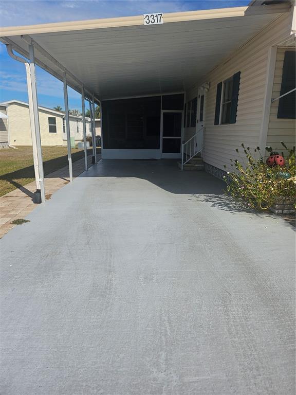 A concrete carport leads to the screened-in entrance of a mobile home — 3317 OVERCUP OAK TERRACE, SARASOTA, FL