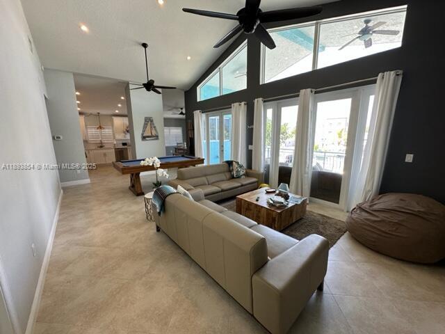 A living room features a tan sofa, a pool table, and large windows with ceiling fans — 62 Waterways Dr, Key Largo FL 33037, KEY LARGO, FL