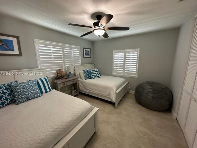 A bedroom features two beds, a ceiling fan, plantation shutters, and a large beanbag chair — 62 Waterways Dr, Key Largo FL 33037, KEY LARGO, FL
