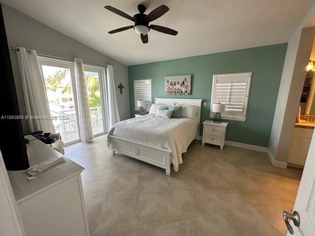 A bedroom features a white bed, a ceiling fan, and a green accent wall — 62 Waterways Dr, Key Largo FL 33037, KEY LARGO, FL