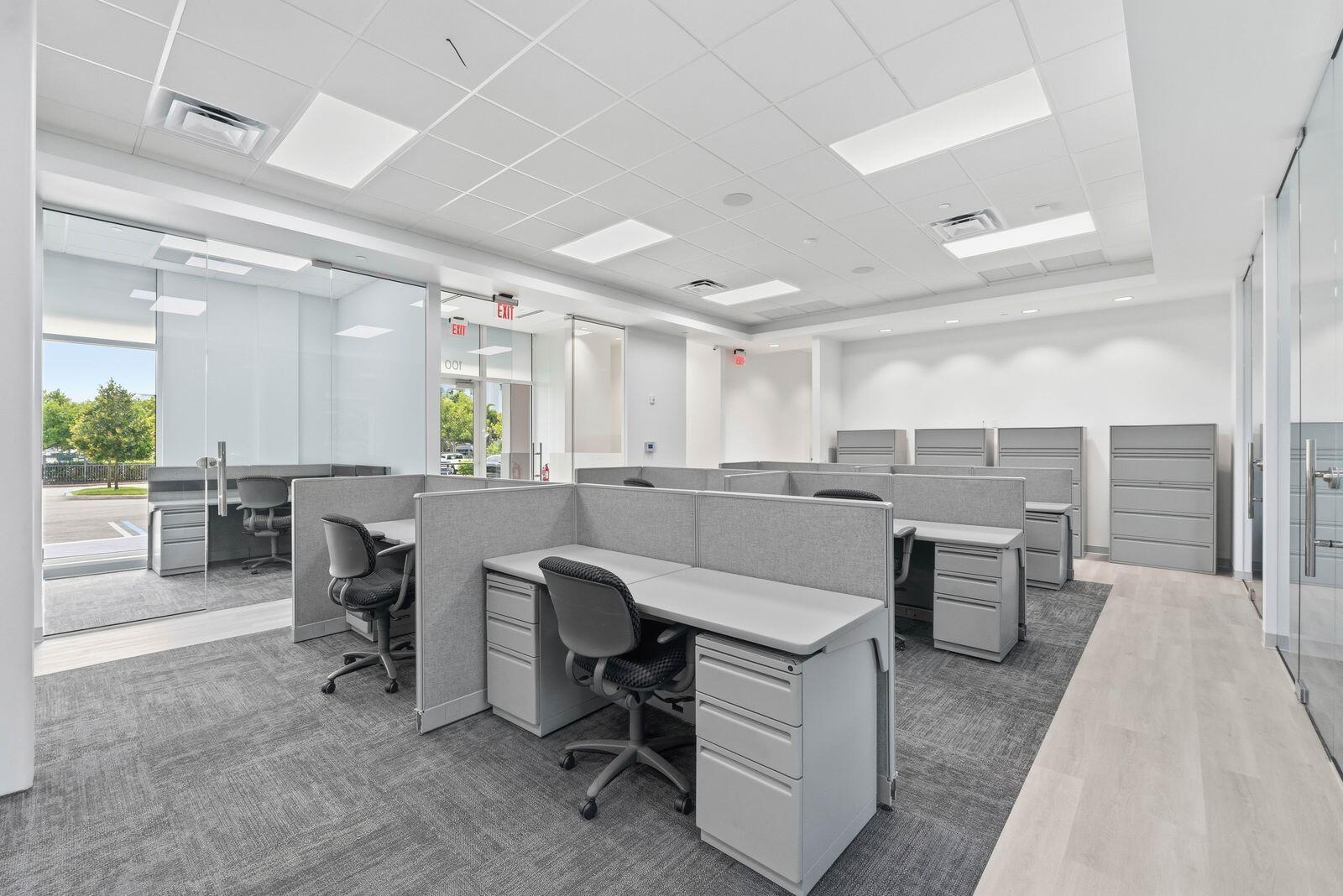 An office space featuring grey cubicles, carpeted flooring, glass partitions, and white drop ceilings — 1300 S Dixie Highway # 14, Lantana FL 33462, LANTANA, FL