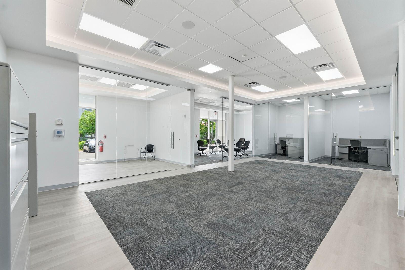 An office interior features glass-walled rooms, a gray carpeted area, and light wood-look flooring — 1300 S Dixie Highway # 14, Lantana FL 33462, LANTANA, FL